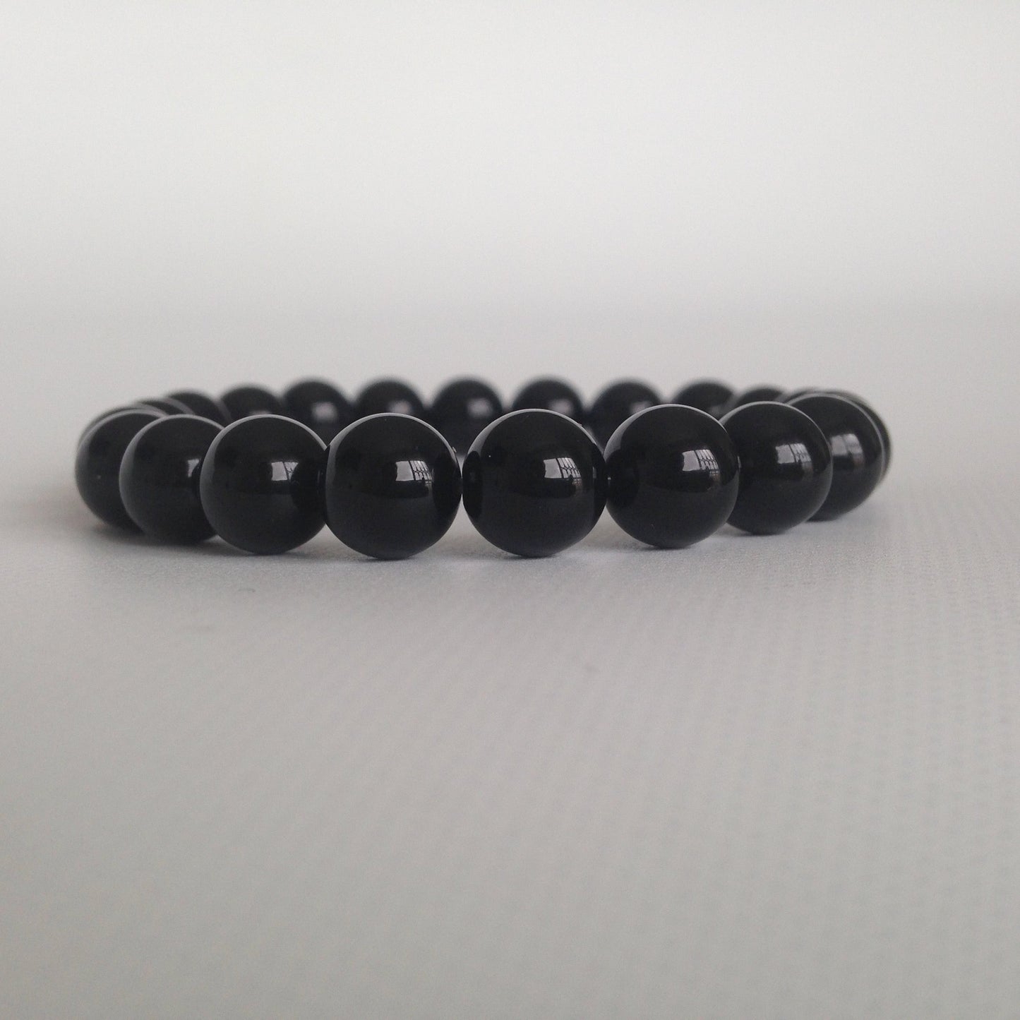 Manilla polo a tierra con onix: limpia y transmuta