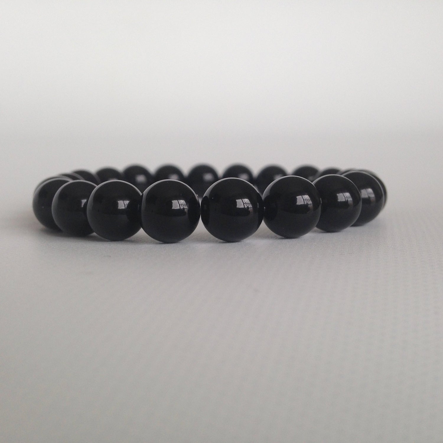 Manilla polo a tierra con onix: limpia y transmuta